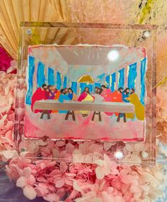 the birth of jesus is displayed in a clear box surrounded by pink and yellow flowers