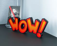 the word wow is lit up in red and yellow letters with a photo behind it