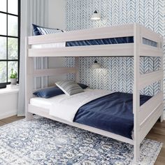 a white bunk bed sitting on top of a wooden floor next to a blue rug