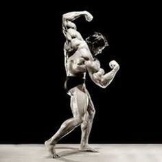 a man standing in the middle of a bodybuilding pose with his arms and legs spread out