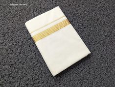 Cotton Off white Double Dhoti (Mundu, in Malayalam) with Golden border - the traditional garment for men which is a symbol of status and culture.  Size -1.25 mtr x 2 mtr Color : Off White Style code available are - SRT 5601, SRT 5602, SRT 5603, SRT 5604, SRT 5605, SRT 5606, SRT 5607, SRT 5608 It is so common to be worn during any occasion. Complement your Indian outfit with this comfy double dhoti that is soft, smooth and silky. You can wear it with a shirt or a kurta. Handloom double dhoti Men' s attire, made of durable, lightweight 100% cotton fabric. Material: Cotton   Hand wash with ordinary soap (avoid detergent) and starching of cloth will give long life and freshness to the dhoti. Please provide your telephone number during check out for easy shipment INTERNATIONAL CUSTOMERS: Intern White Dabka Set For Puja, Traditional White Gift Sets, White Dupatta For Puja On Eid, White Dupatta For Puja Eid, White Dupatta For Eid Puja, Eid Puja White Dupatta, White Handloom Kurta For Puja, White Kurta With Traditional Patterns For Navratri, White Traditional Wear For Navratri Puja