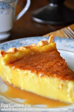 a slice of cheesecake on a blue and white plate with coffee in the background