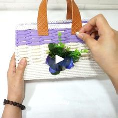 a person is holding a woven bag with flowers in the front and on the inside