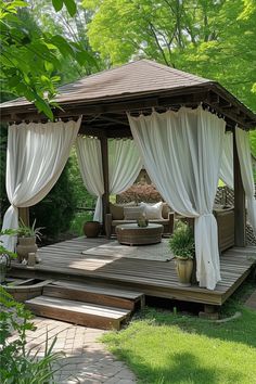 a wooden gazebo with white drapes on it