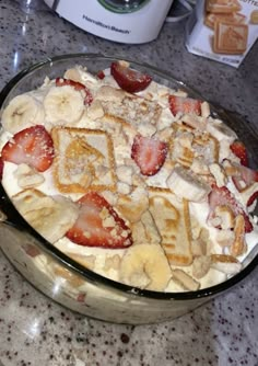 a bowl filled with waffles and strawberries on top of a counter next to an air fryer