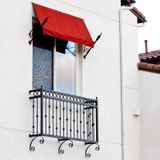 a white building with a red awning next to a black and white balcony railing