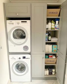 a washer and dryer in a small room next to some shelves with bottles