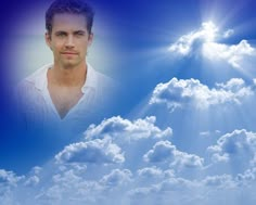 a man standing in front of a blue sky with clouds and the sun behind him