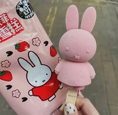 a person holding up a pink bag with a bunny on it