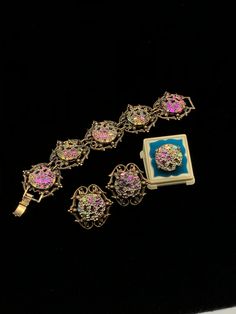 "This color changing set is oh so pretty; each round 'stone' in the bracelet and clip earrings is set in a decorative brass colored metal which measures 1 1/2\" long by 1 1/2\" wide; the ring is set in a simple setting of the same colored metal; depending on the angle, the colors reflect blue, pink, green, yellow or orange; bracelet is 7 1/2\" long, and each 'stone' is 7/8\" round; dress up or down." Collectible Jewelry With Jewels, Collectible Jewels Bracelet, Collectible Jeweled Bracelet, Elegant Multicolor Brass Jewelry, Adjustable Brass Jewelry For Collectors, Elegant Iridescent Bracelet Jewelry, Antique Brass Jewelry For Party, Victorian Style Metal Jewelry With Jewels, Adjustable Iridescent Jewelry For Wedding