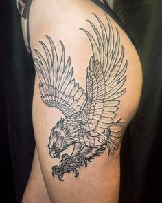 an eagle tattoo on the back of a woman's thigh