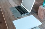 an open laptop computer sitting on top of a wooden table