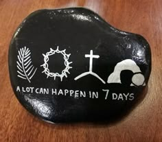 a rock with the words a lot can happen in 7 days written on it and an image of a cross