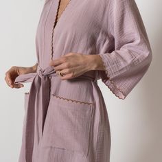 Wrap up in the softest kimono style robe! Made from lightweight and breathable combed cotton, with contrast scalloped edge detailing. Finished with patch style pockets and bracelet length sleeves. The perfect beach cover-up or just for lounging at home, this will be a staple in your Summer wardrobe. Features -Scalloped edges -Two patch front pockets -Waist tie with side belt loops -Bracelet length sleeves Please Note: Monogrammed items are hand stitched and may take up to 5 business days for pro Spring Sleepwear With Pockets For Relaxation, Chic Summer Sleep Robe, Summer Robe With Lace Trim For Daywear, Cotton Kimono For Spring Lounging, Spring Cotton Kimono For Lounging, Cotton Sleepwear With Kimono Sleeves, Cotton Sleepwear With Kimono Sleeves For Loungewear, Feminine Open Front Robe For Loungewear, Summer Cotton Kimono With Pockets