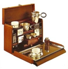 an open wooden box with cups and saucers in it