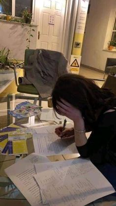 a woman sitting at a table with papers on it