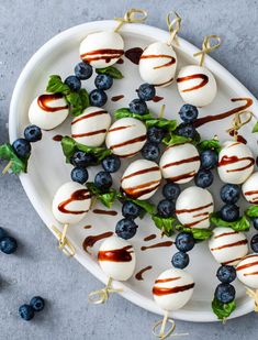 blueberry caprese skewers on a white plate