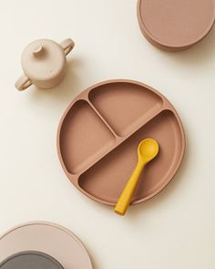 a yellow spoon sits on top of a divided plate