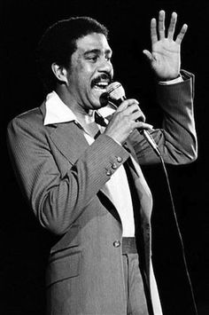 a man in a suit singing into a microphone