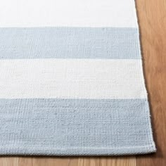 a blue and white striped rug sitting on top of a wooden floor