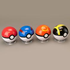 four different colored pokemon balls lined up in a row