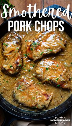 pork chops with gravy in a skillet on top of a wooden table