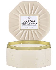 voluspa coconut papaya candle in a white container with gold trim around the edge