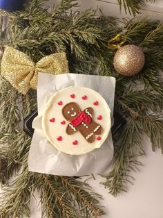 a decorated cookie sitting on top of a piece of wax paper next to christmas decorations