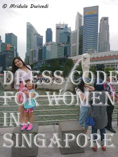 two girls are standing in front of a fountain with the words dress code for women in singapore