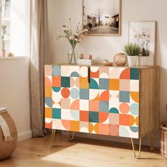 an orange, blue and green patterned cabinet in a living room