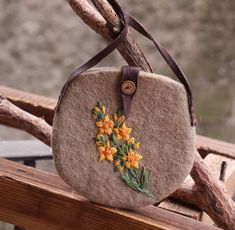 a handbag with flowers on it sitting on a wooden bench