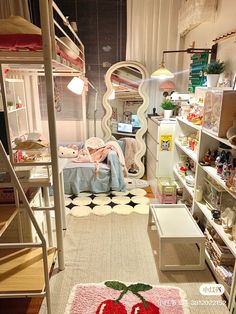 a bedroom with bunk beds and shelves full of stuff on the floor in front of it