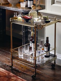 a bar cart with bottles and glasses on it