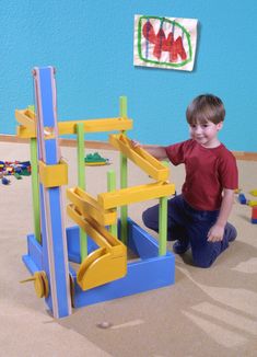 a young boy playing with toys in a room