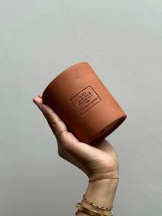 a person holding up a brown cup in their hand