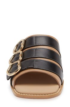 Whether you're polishing up your casual office look or dressing up for brunch, this buckled slide sandal will enhance a variety of looks. Leather upper and lining/rubber sole Made in Portugal Black Owned/Founded Elegant Leather Slides With Buckle Closure, Designer Open Toe Sandals With Gold Buckle, Designer Summer Slides With Tang Buckle, Designer Slides With Tang Buckle For Summer, Designer Black Sandals With Rectangular Buckle, Designer Leather Sandals With Gold Buckle, Designer Open Toe Slides With Buckle Closure, Designer Sandals With Leather Footbed And Rectangular Buckle, Leather Slide Mules With Tang Buckle