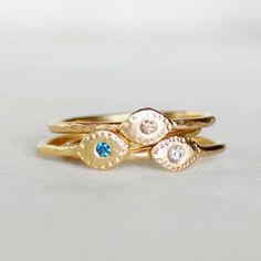 "Sparkly teal blue diamond \"Evil Eye\" ring. Diamond - 1.7mm - conflict-free, teal blue (treated to enhance color) Band - Hammered gold band...choose between 1.3mm and 1.6mm thickness Eye - 4mmx6mm Gold - 14k (18k Gold available. Pricing on request) Size - Please leave your ring size in the \"message to seller\" section at checkout **When you check out, choose: 1.3mm or 1.6mm band width...if you are stacking with one of my 1.6mm bands, choose the 1.6mm. If you are stacking it with one of my 1.3 Handmade 14k Gold Sapphire Promise Ring, Gold Topaz Birthstone Ring With Diamond, Handmade Gold Topaz Promise Ring, Handmade Yellow Gold Birthstone Ring In Fine Jewelry Style, Handmade Yellow Gold Birthstone Ring Fine Jewelry, Unique Yellow Gold Birthstone Ring, Unique Yellow Gold Ring With Birthstone, Gold Sapphire Stackable Rings For Gift, Handmade 14k Gold Birthstone Ring For Anniversary