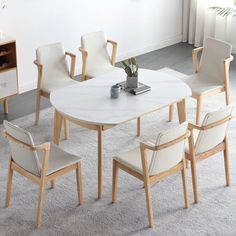 a white table with chairs around it and a plant in the middle, on a carpeted floor