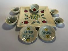 an assortment of bowls and plates with the word god in hebrew written on one side