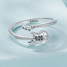 The Guitar Ring is a stylish gift to music lovers with minute features that resemble a guitar's form. This unique item gives your appearance a rock 'n' roll edge and is ideal for showing off your love of music. Gender: Women Width: 1.8mm Material: 100% 925 sterling silver Style: TRENDY Main Stone: Zircon Rings Type: Cocktail Ring Item Type: Rings Item Weight: 2.3 g Side Stone: None Shape\pattern: Irregular Metal Stamp: 925, Sterling Adjustable Metal Punk Rings, Adjustable Punk Metal Rings, Adjustable Punk Style Metal Rings, Adjustable Music-themed Jewelry For Concerts, Music Gender, Guitar Ring, Zircon Rings, Ear Cuff Jewelry, Stackable Rings Silver