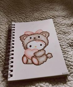 a drawing of a teddy bear with a pink bow on it's head sitting on a bed