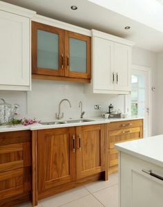 a kitchen with white counter tops and wooden cabinets