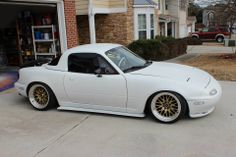 a white sports car parked in front of a garage