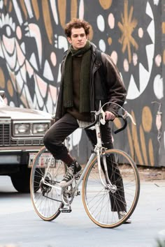 a young man is riding his bike down the street