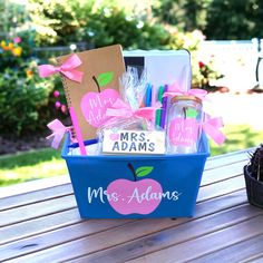 a teacher's gift basket on a picnic table with personalized items in it