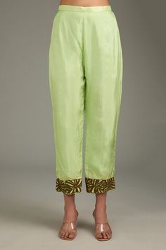 Lime green straight kurta featuring contrasting brown floral cutwork embroidery. Paired with coordinating pants that have similar detailing at the hem., Fit: Relaxed Spring Pista Green Set With Embroidered Border, Designer Wear Fitted Palazzo Set With Straight Pants, Designer Fitted Palazzo Set With Straight Pants, Fitted Pant Set With Gota Work, Spring Silk Designer Pant Set, Summer Silk Palazzo Set With Gota Work, Spring Green Traditional Wear With Embroidered Border, Festive Green Bottoms With Resham Embroidery, Zari Work Pant Set For Summer