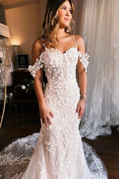 a woman in a white wedding dress posing for the camera with her hands on her hips