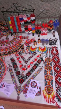 a table topped with lots of different types of beaded bracelets and necklaces