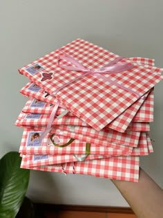 a stack of red and white checkered paper with pink ribbon tied to the top