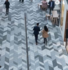 two people walking down the middle of a walkway